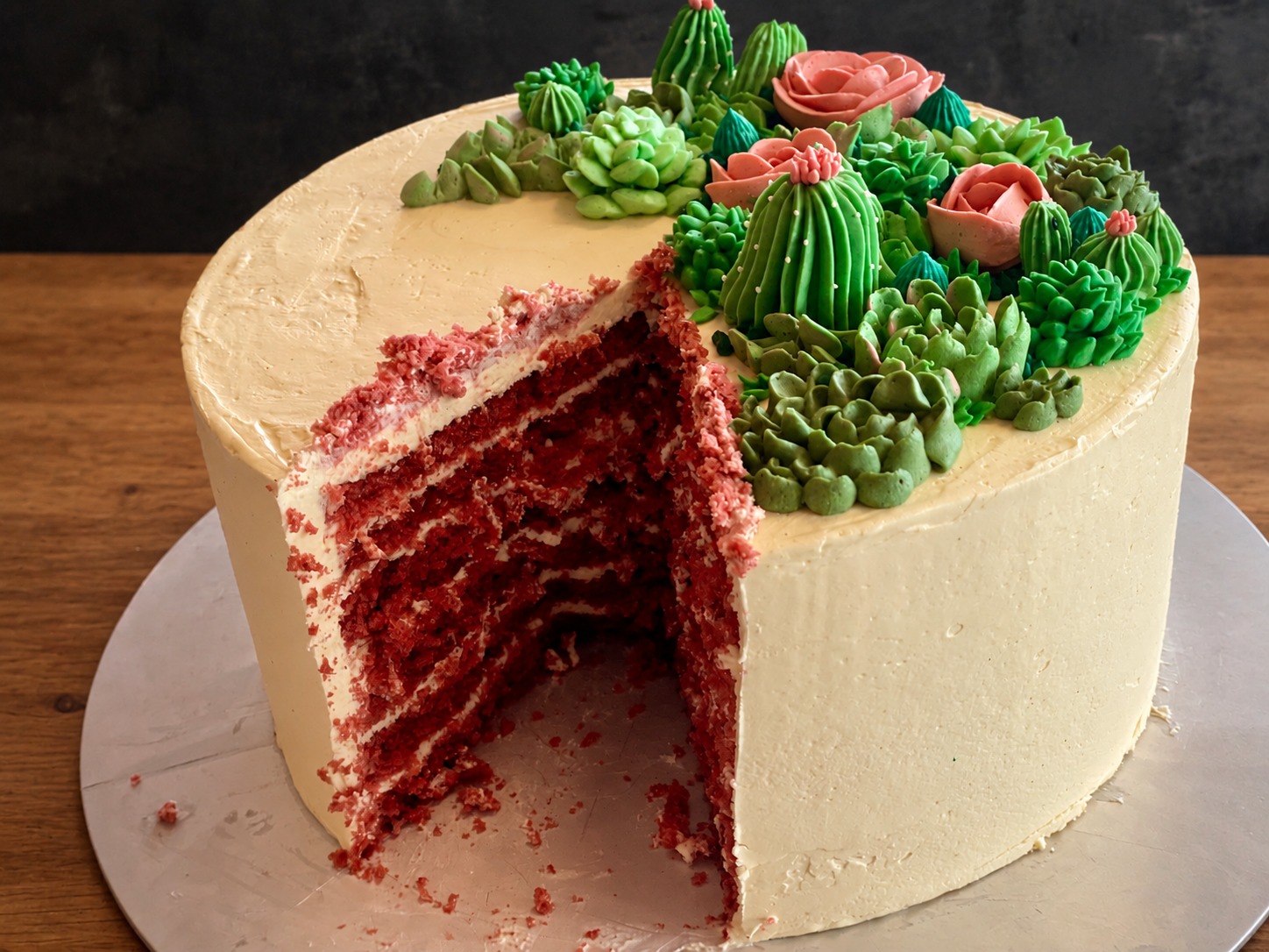 Angeschnittene Torte mit roten Böden und Sukkulentendekoration