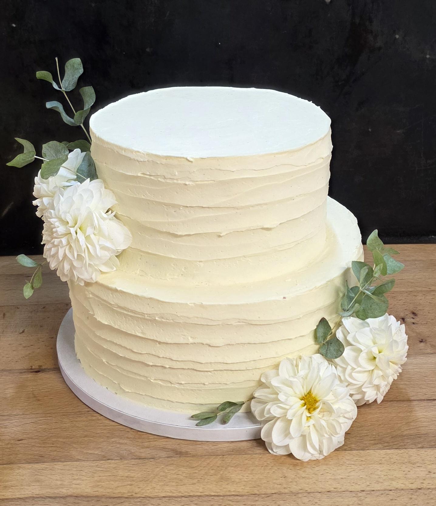 Zweistöckige Hochzeitstorte mit weißen Blumen